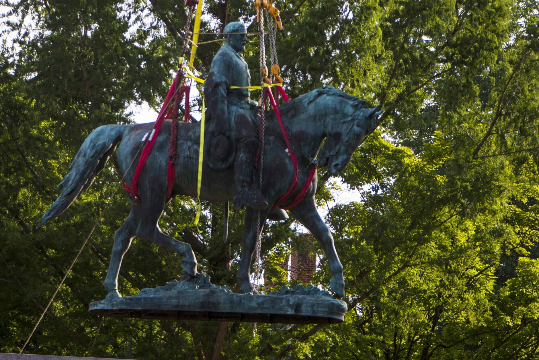 Workers remove the monument of Confederate General Robert E. Lee on Saturday, July 10, 2021 in Charlottesville, Va.   The removal of the Lee statue follows years of contention, community anguish and legal fights. (AP Photo/John C. Clark)